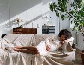 A pregnant woman lying on a sofa in a room full of natural light