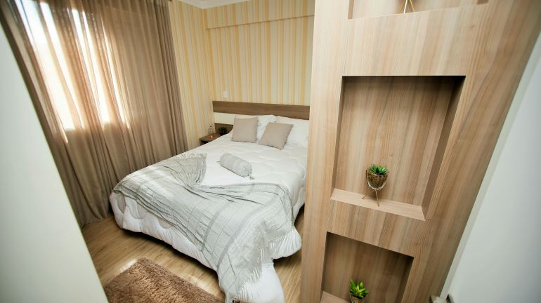 Tag: A compact bedroom with built-in shelves and soft lighting.