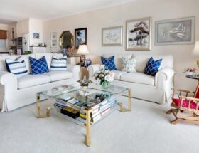 An elegant living room with framed artwork, white sofas, and bold cushions shows how to choose the right art pieces to complete your home design.